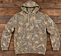 Chasing Dreams camouflage pullover hoodie with cream chest logo and American flag sleeve graphic