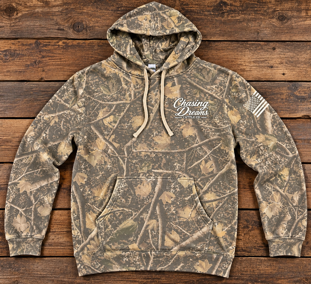 Chasing Dreams camouflage pullover hoodie with cream chest logo and American flag sleeve graphic